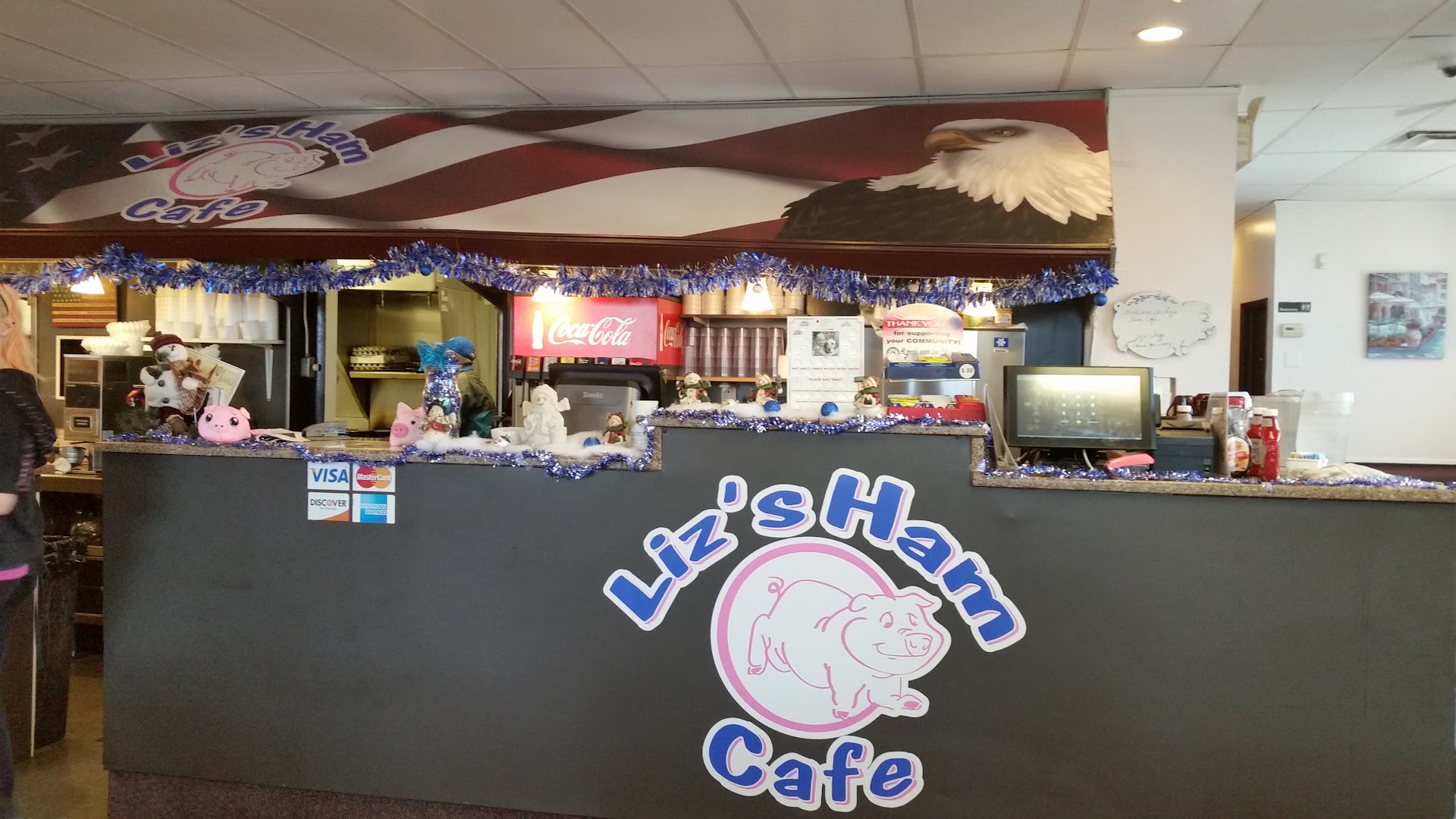 The front counter at Liz's Ham Cafe with the pink pig logo and stars-and-stripes mural
